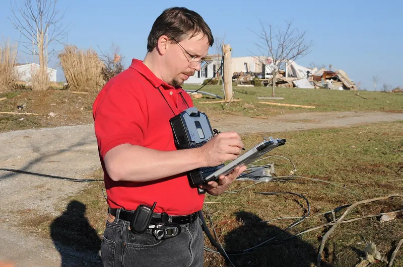 Damage assessor recording property damage on a rugged tablet at a disaster site