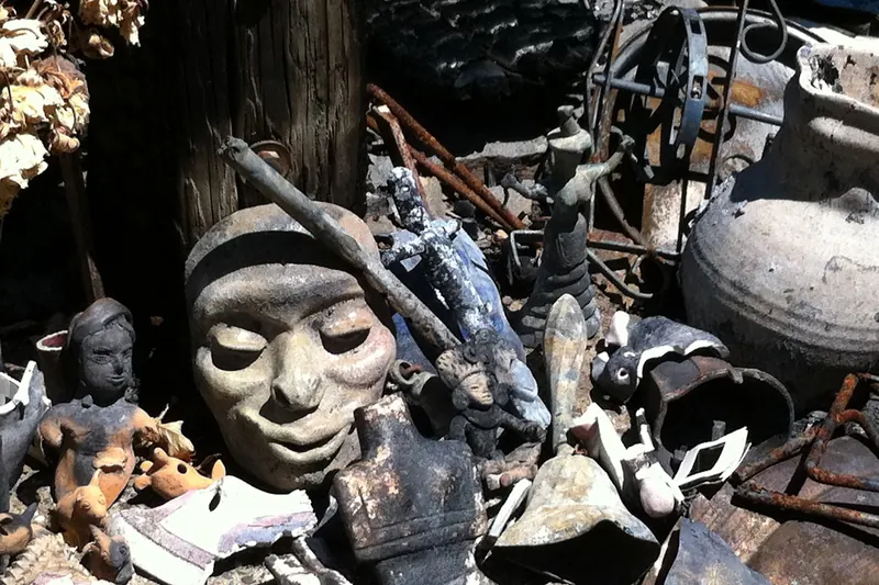 Pile of burned and blackened household belongings and figurines after a fire