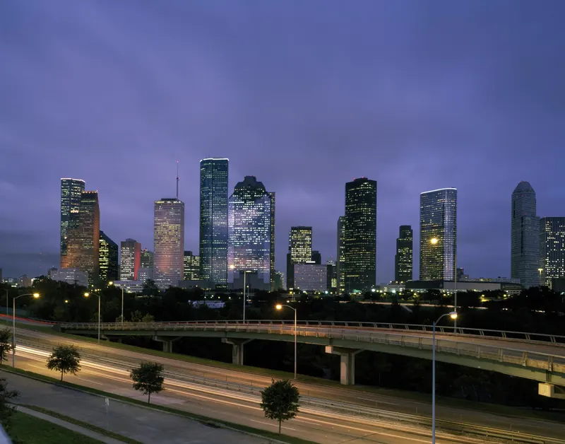 Downtown Houston skyline at dusk above a lighted freeway