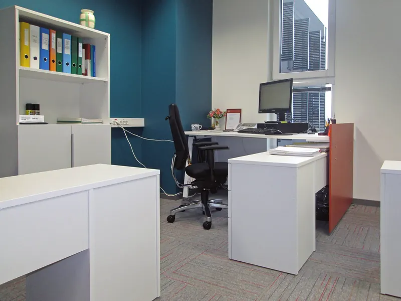 Modern office interior with white desks, task chairs and shelving