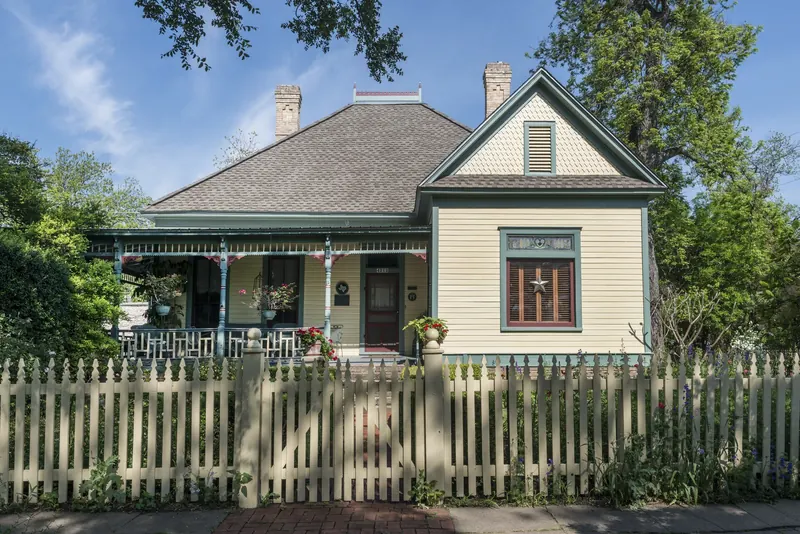 Historic cottage with a front porch and white picket fence in Austin, Texas